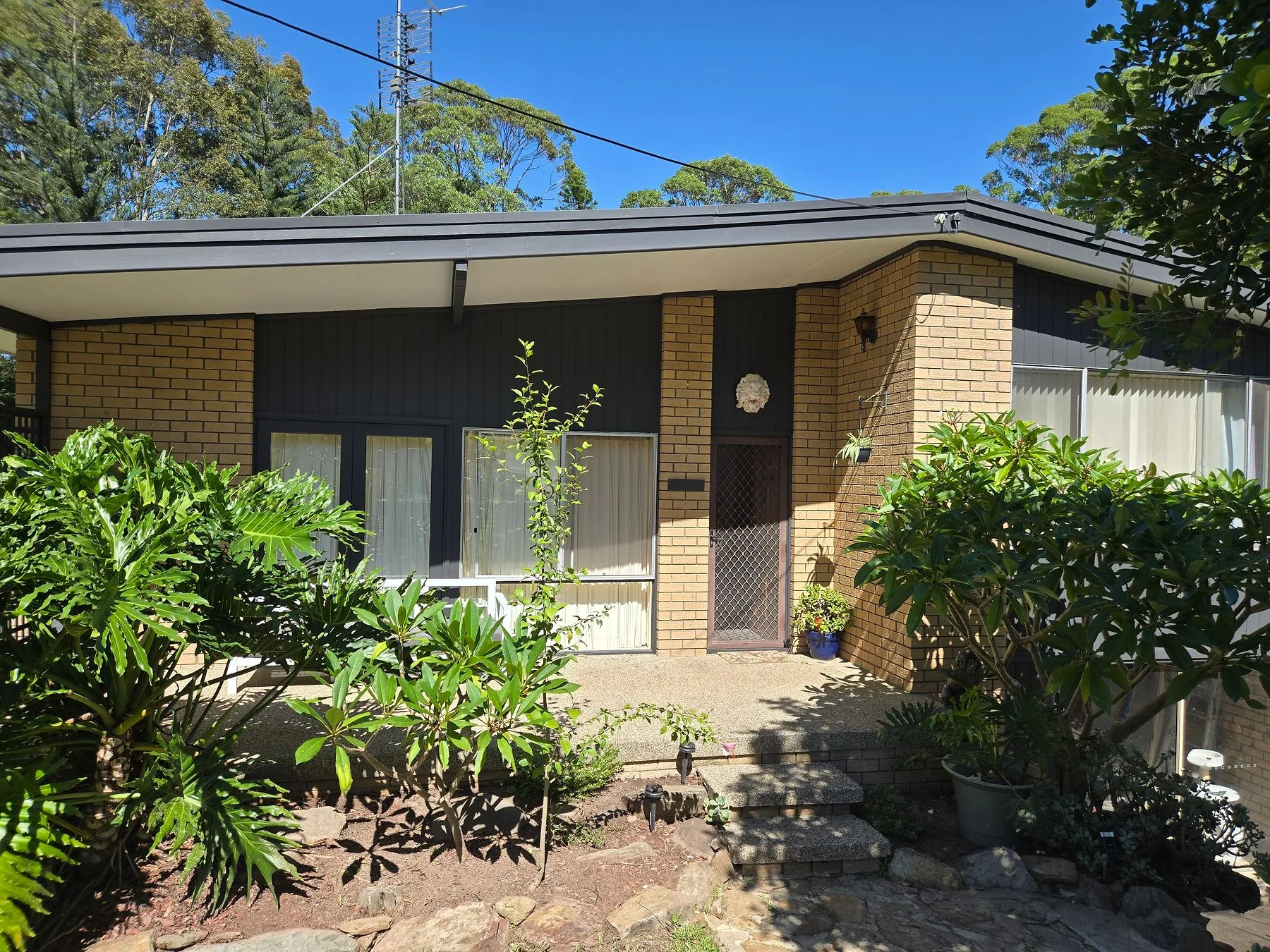 A brick and weatherboard house with fascia and cladding newly painted in Dulux Monument